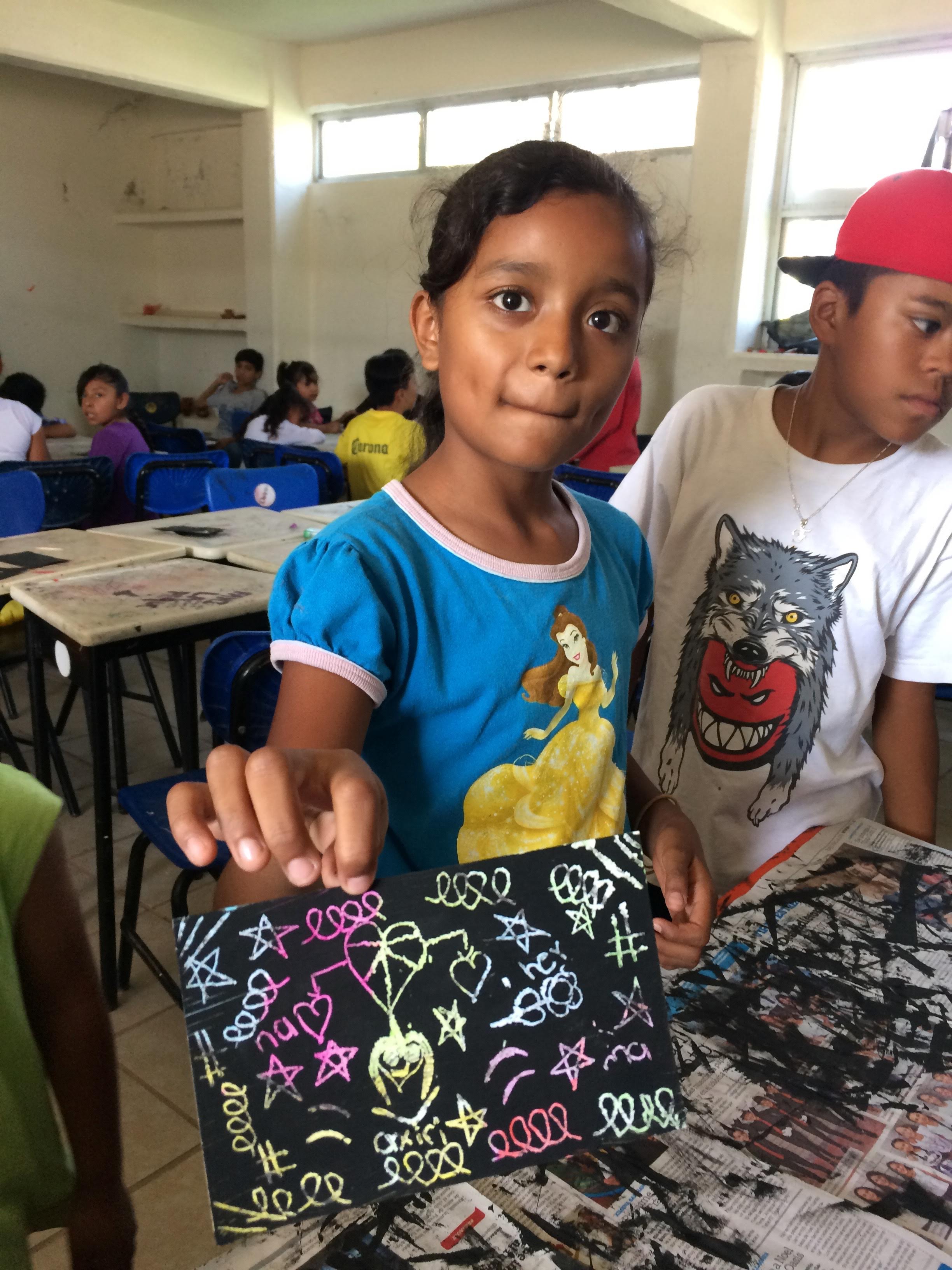 Niña enseñando el dibujo que realizó