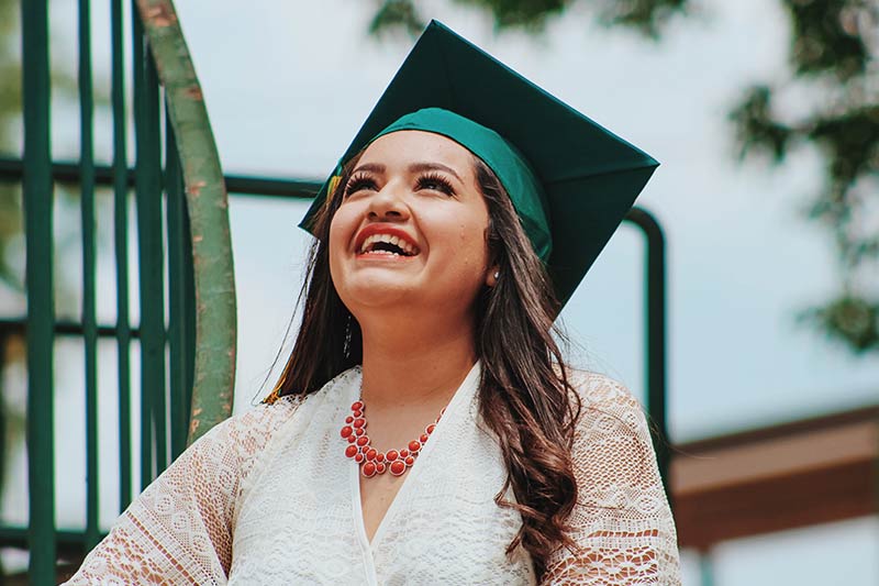 Imagen de una estudiante recién graduada, sonriendo