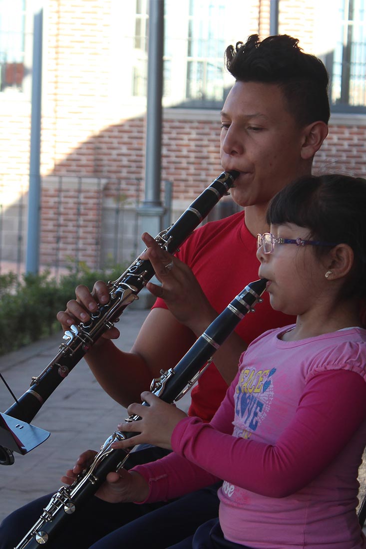 Niño y adolescente ensayando clarinete